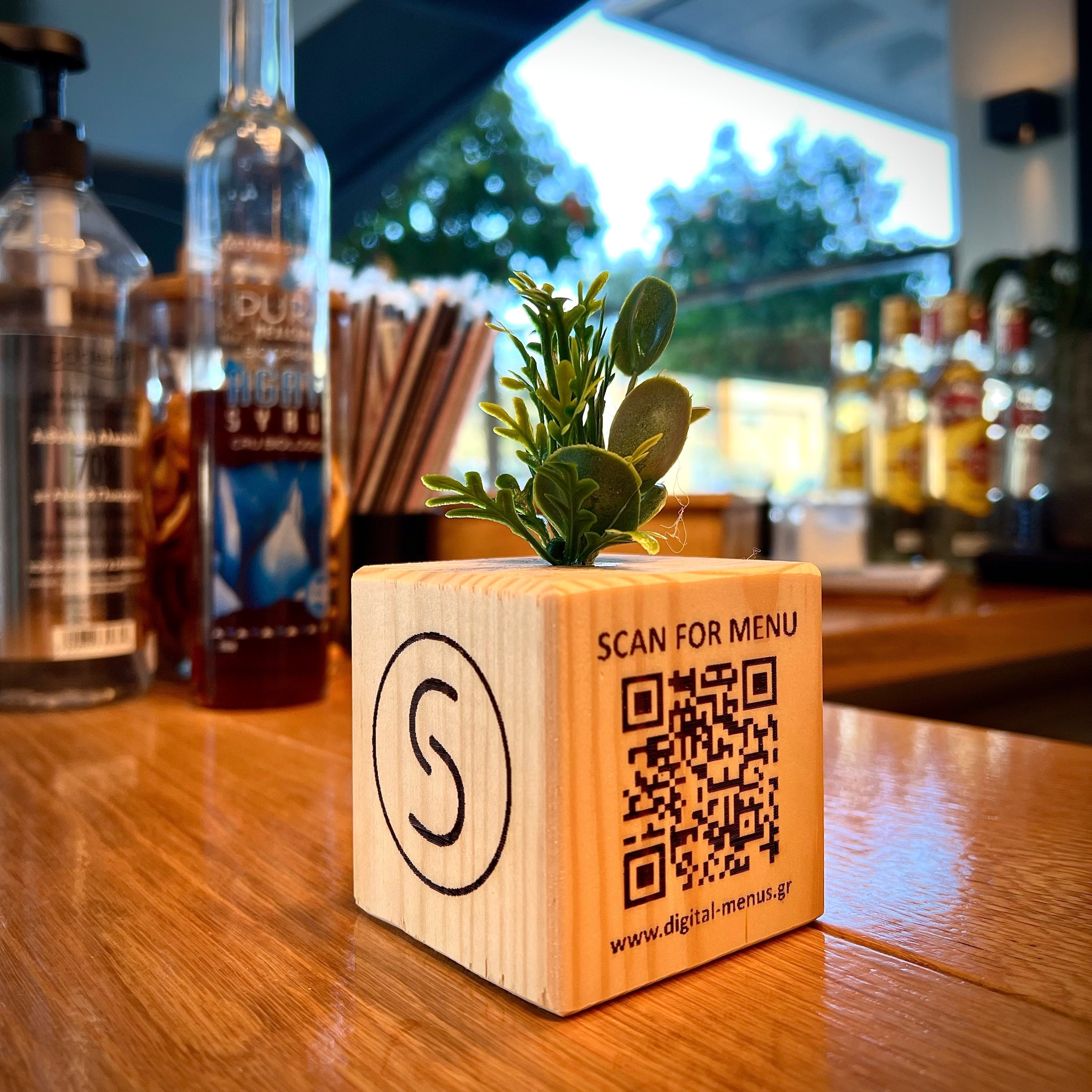 A wooden QR Cube plced on a bar