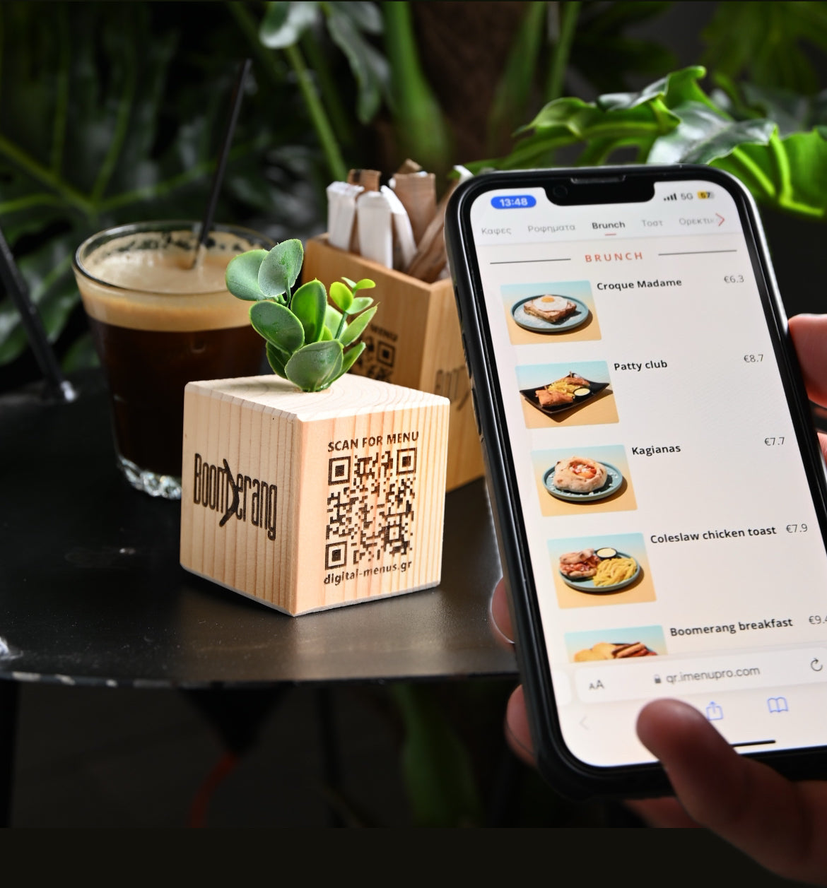 A wooden cube with a QR Code engraved, scanned from a smartphone and showing the menu